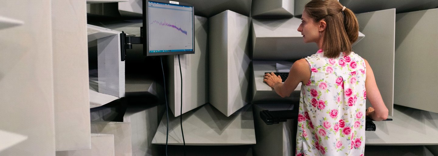 Female noise and vibration engineer collects sound data in an anechoic chamber