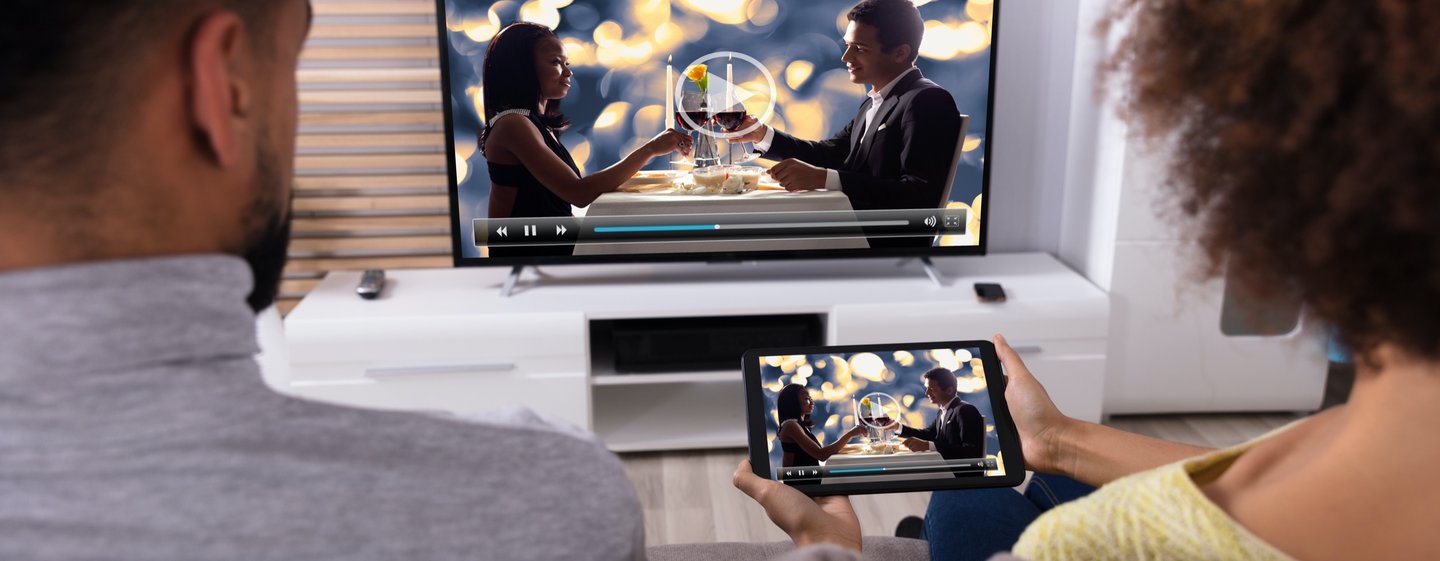 Couple watching streaming content from a smartphone to a smart tv